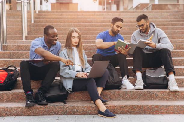 istock Diverse Group of Students Studying Together on University Campus Steps with Laptops and Books 2176130481