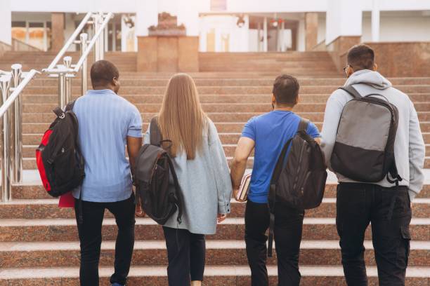 istock Group of Diverse College Students Walking Up Stairs on Campus With Backpacks 2176130529