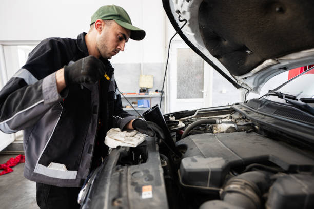 istock Mechanic checking engine oil level in an auto repair shop 2176132115