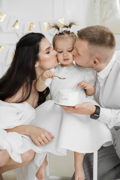 istock Parents celebrate daughters second birthday with cake and love 2176132999