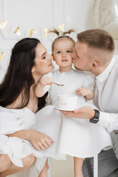 istock Parents celebrate daughters second birthday with cake and love 2176133040