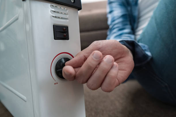 istock Turning on heater at home during heating season, featuring smart heaters with remote control and temperature adjustment via smartphone. 2176135375