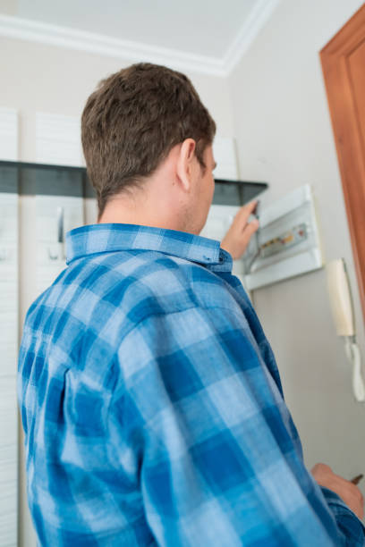 istock Man standing by an electrical panel, repairing it after a power failure, emphasizing safety services for electrical installations. 2176135414