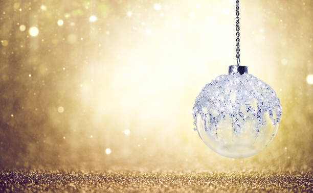istock White Glass Christmas Bauble against a Sparkling Golden Background 2176136190