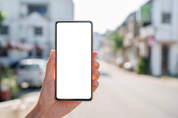 istock A hand holding a mobile smartphone with a blank screen, set against a blurred street background 2176141742