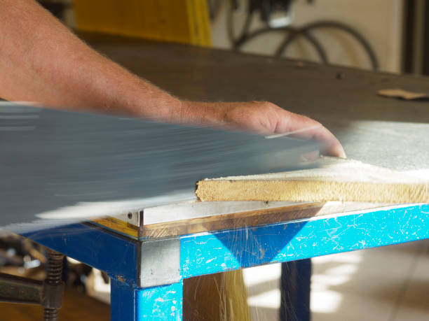 istock Carpenter sanding wood with sandpaper in workshop 2176142726