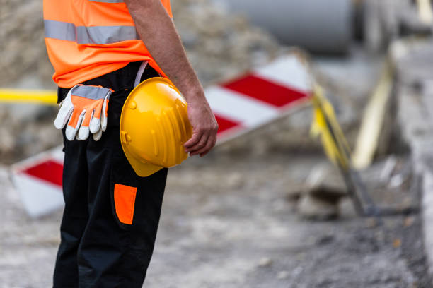 istock Construction worker stands by a work site with a hard hat and wearing safety gear during the day at a construction zone 2176145209