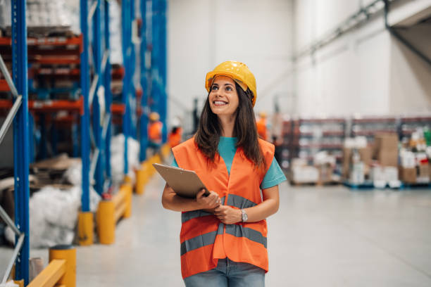 istock Woman warehouse supervisor with hard hat oversees operations confidently 2176149600