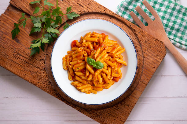 istock Macaroni with tomato and basil aroma. Top view table with decorations. 2176151253