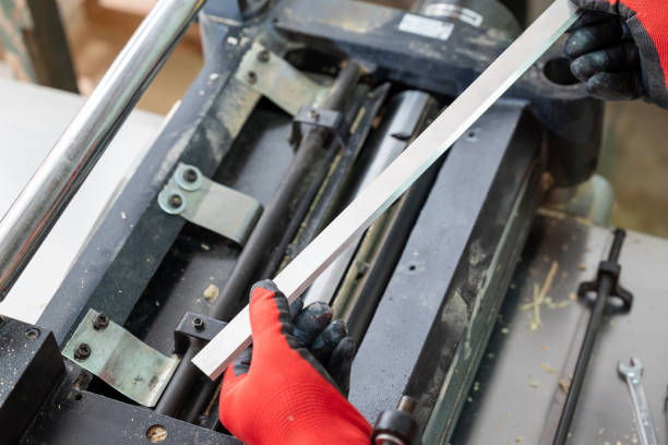 istock Joiner installing new sharp knives to his machine for cutting and sanding wood 2176153707