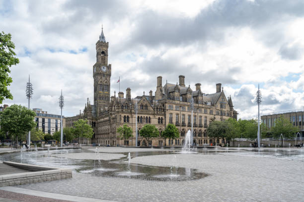 09.08.2024 Bradford, UK. The impressive Bradford City Hall overlooks the vibrant Centenary Square, with its interactive fountains and spacious plaza. This grand Victorian building, with its clock tower and intricate architecture, stands as a symbol of Bradford’s rich heritage.