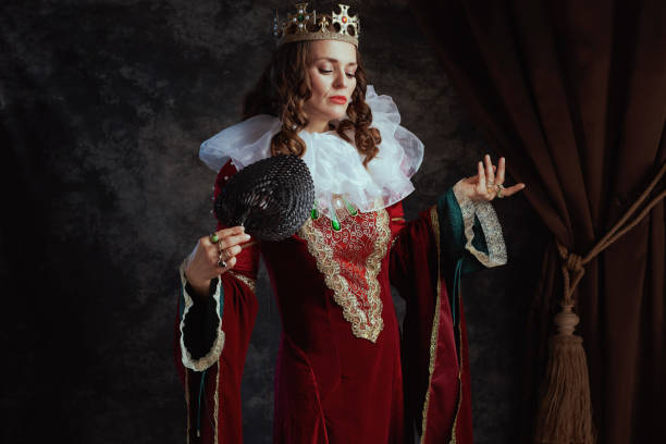 Young woman dressed like an evil queen standing in the forest.