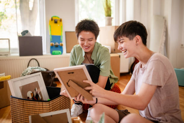 istock Two friends laughing and bonding over framed pictures. 2176156330