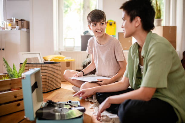 istock Bond over tunes: friends with a retro music setup. 2176161777