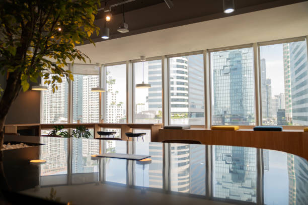 Modern coworking space, located in a bustling business district surrounded by tall buildings, features stylish furniture, an open-plan design, and ample natural light. Ideal for collaboration and creativity, it offers a professional atmosphere for business meetings, workshops, and networking opportunities in today's dynamic corporate environment.