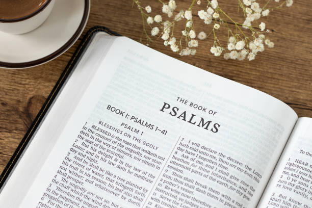 Psalms open holy bible book with coffee cup on wooden table