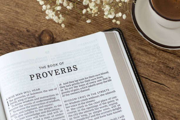 istock Proverbs open holy bible book with coffee cup on wooden desk 2176173984