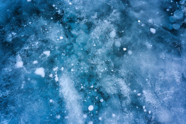 istock Natural methane bubbles in frozen lake on winter 2176175224