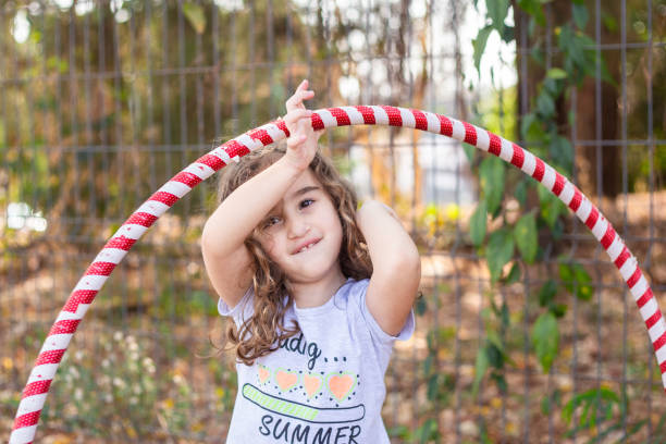 istock A girl playing with a hula hoop. 2176176339