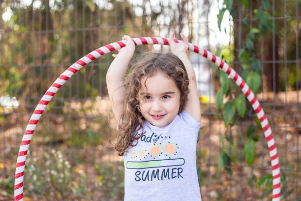 istock A girl playing with a hula hoop. 2176176345