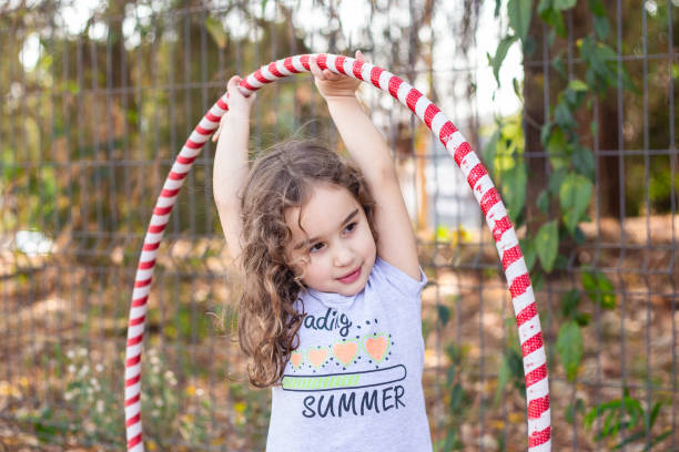 istock A girl playing with a hula hoop. 2176176358
