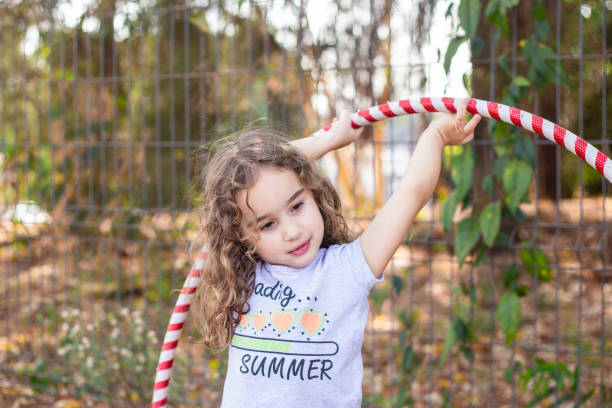 istock A girl playing with a hula hoop. 2176176363