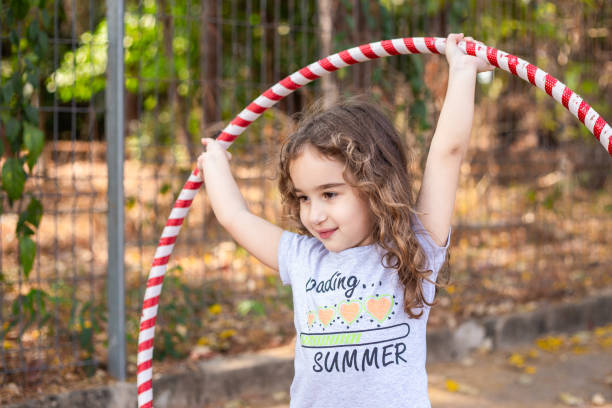 istock A girl playing with a hula hoop. 2176176368
