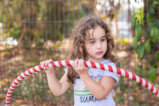 istock A girl playing with a hula hoop. 2176176374