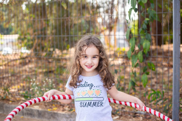 istock A girl playing with a hula hoop. 2176176375