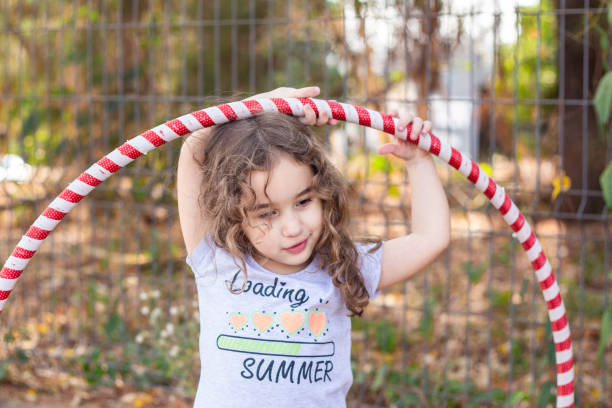 istock A girl playing with a hula hoop. 2176176376