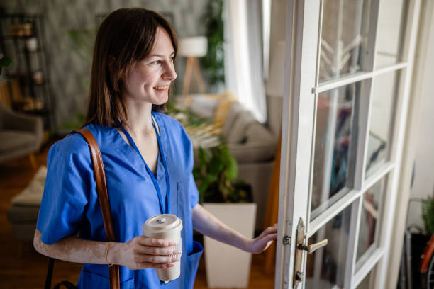 istock Happy nurse with coffee at door looking out to the world 2176176830
