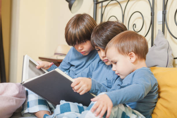 istock Children reading a storybook together on the bed 2176177385