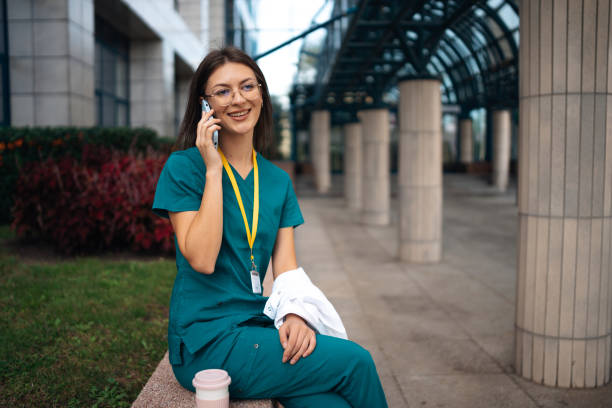 istock Nurse talking on phone with coat in urban space. 2176180441