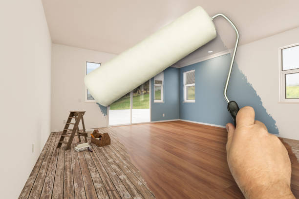 istock Before and After of Man Using A Paint Roller to Reveal Newly Remodeled Room with Fresh Green Paint, Coffered Ceiling and New Floors. 2176182997