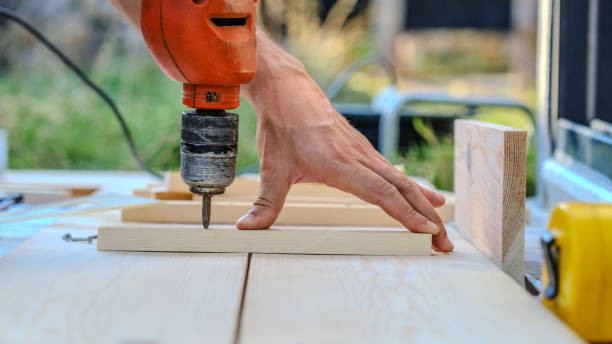 istock A close-up view of a man using a cordless screwdriver while making furniture with timber in the garden of his house on a summer day 2176185307