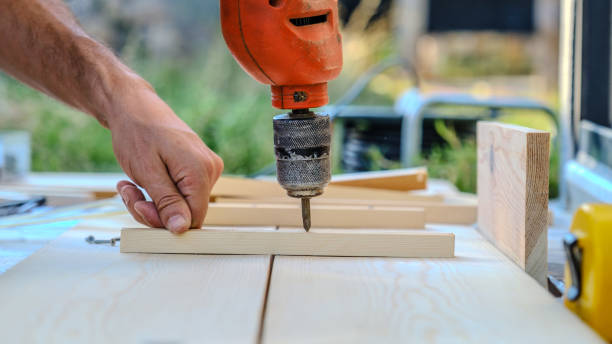 istock A close-up view of a man using a cordless screwdriver while making furniture with timber in the garden of his house on a summer day 2176185311