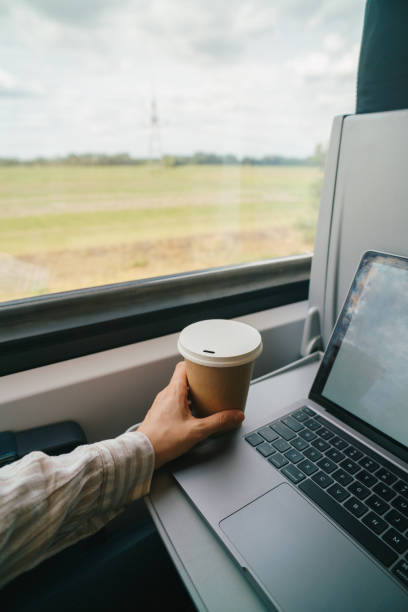 Morning commute with coffee and laptop on a train
