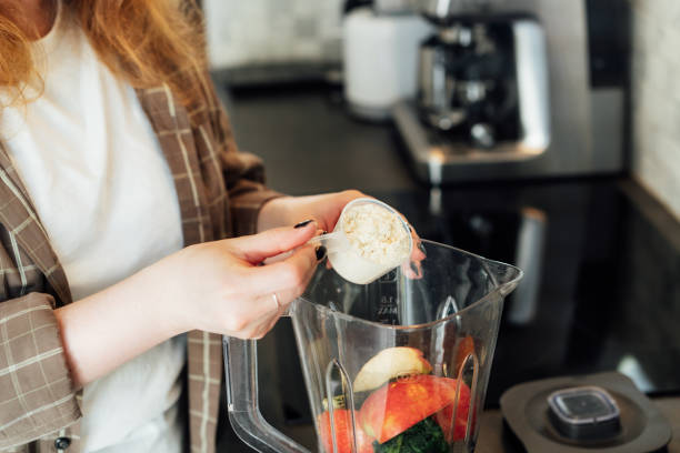 istock Close up woman adding plant based pea protein powder during making smoothie on the kitchen. Superfood supplement. Healthy nutritional vegan diet. Healthy dieting eating, weight loss program. 2176189267