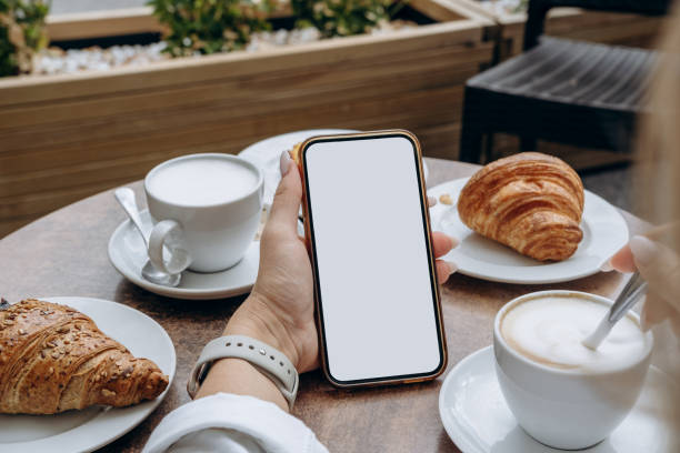 istock Mockup woman's hand holding using smart phone with white blank screen POV at coffee shop, mobile app design and advertising, online marketing 2176189463