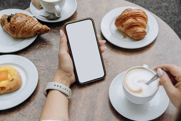 istock Mockup woman's hand holding using smart phone with white blank screen POV at coffee shop, mobile app design and advertising, online marketing 2176189493