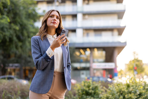 istock Middle aged woman holding her smartphone while strolling through the city 2176192535