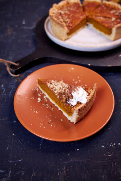 istock pumpkin pie on a dark background on a terra cotta plate. Top view 2176196383