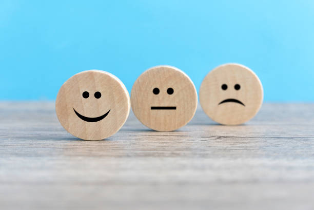 istock Emotional Spectrum: Three Wooden Circles with Happy, Sad, and Neutral Faces on a Vibrant Blue Background 2176196481