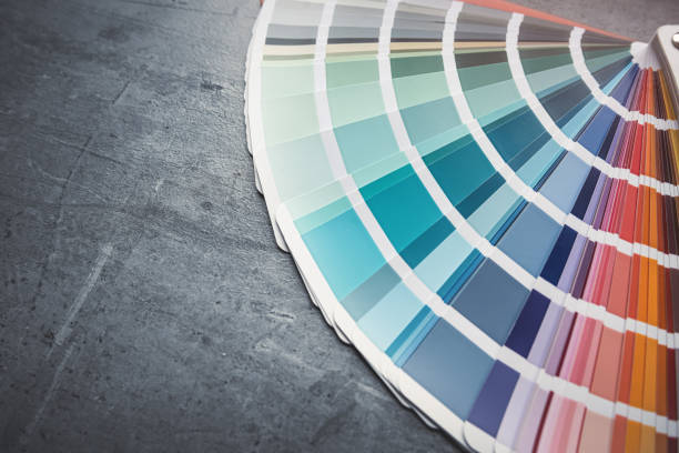 Rainbow catalog of paints with a various color palette on grey desk. Colored catalog