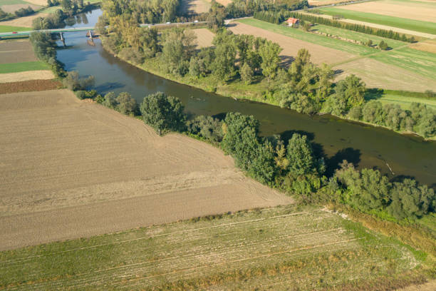 istock Aerial view of a pristine river winding through fields and trees, showcasing the beauty of nature and agricultural landscapes 2176208374