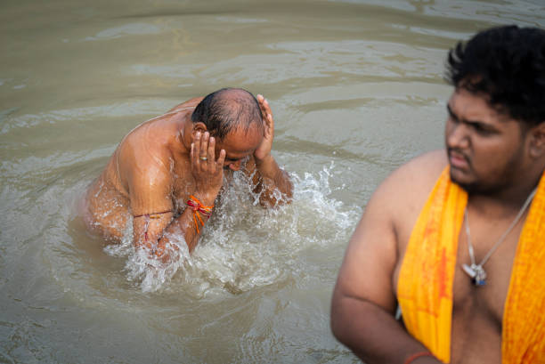 Hindu devotees perform the 'Tarpan' ritual during Mahalaya prayers, also known as Pitru Paksha, at the Brahmaputra river, in Guwahati, India on 2 October 2024.  Mahalaya is observed seven days before the Hindu festival Durga Puja, with devotees offering prayers to pay obeisance to their deceased forefathers.