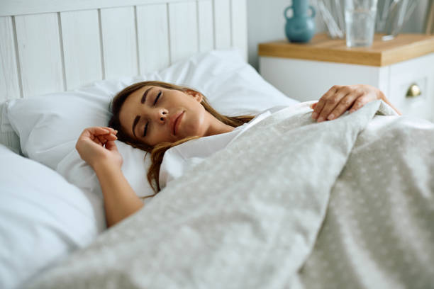 istock Young woman sleeping in a bed at home. 2176213913