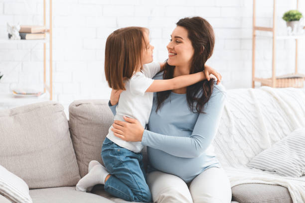 istock Little kid hugging pregnant mom, home interior 2176214185