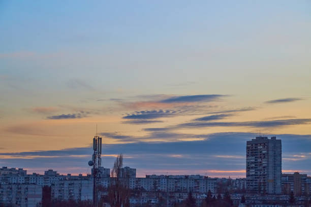 Evening sky illuminated by the sun above a twilight city without lights.