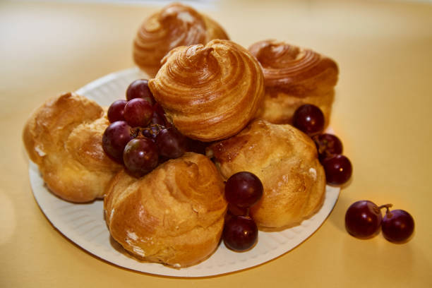 istock Delicious profiteroles and grapes on a white plate, aesthetic presentation for culinary websites. 2176215457